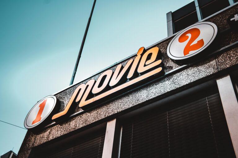Fasada kina z oznakowaniem „TOP 10 filmów kryminalnych” i „film 2” na tle czystego nieba.